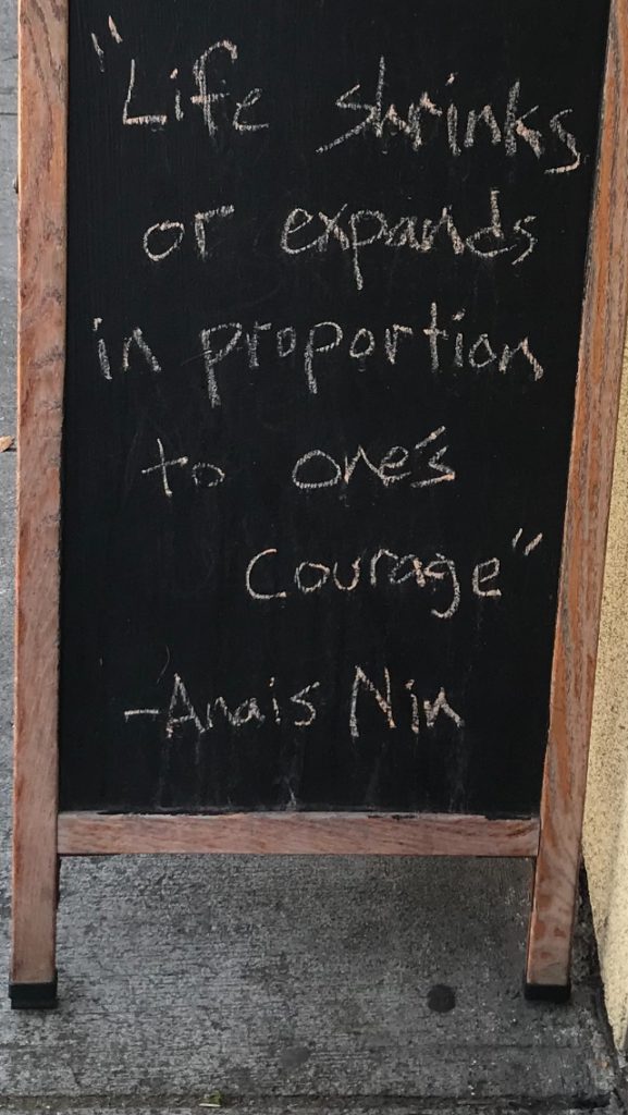 Billboard with quote: Life shrinks or expands in proportion to one's courage.